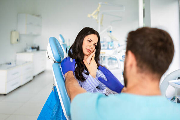 Young Woman Experiencing Toothache at Dental Clinic